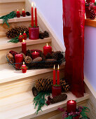 Treppe weihnachtlich dekoriert mit Kerzen, Zapfen und Zweigen