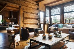 Leather armchairs and animal-skin rugs in comfortable lounge area of dacha