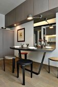 Minimalist dining area below wall-mounted cupboards