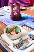 Asian table setting with small bowls, cutlery and tea light