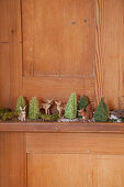 Miniature forest of animal figurines and tiny crocheted trees