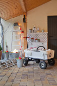 Pull-along cart and Christmas decorations under porch