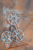 String art with cogs on rust-coloured background