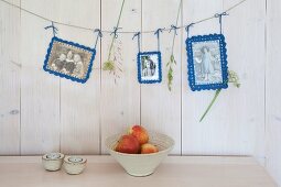 Old photos with crocheted picture frames hung from line