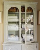 Towels in glass-fronted linen cupboard