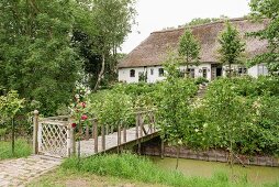 Traditionelles friesisches Bauernhaus aus dem 17. Jahrhundert mit Holzsteg über Bachlauf