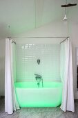 Grün beleuchtete weiße Badewanne mit Duschvorhang in modernisiertem Altbau