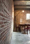 Candlesticks and laptop in illuminated dining area with brick walls