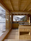 Kitchen in modern wooden house with view of wintry landscape