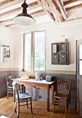 Rustic kitchen table, wooden chairs and vintage post boxes hung on wall