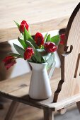 Red tulips in white jug