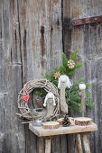 Angels hand-made from driftwood on wooden stool against wooden door