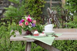 Wildly romantic bouquet on garden table set for afternoon coffee