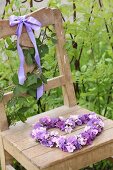 Hydrangea and phlox flowers arranged in love heart on old wooden chair