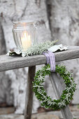 Wreath of box and santolina with ribbon on wooden bench