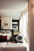 View across sofa into open-plan interior with dining table and kitchen