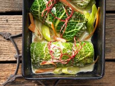 Vegetarian savoy cabbage roulade filled with green peas, walnuts and fresh herbs