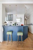 Two retro bar stools at counter in restored period apartment