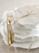 A Christmas table setting with a ribbon and gold cutlery