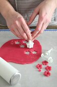 Flowers being cut out of rolled-out marzipan