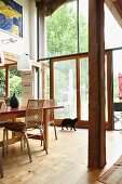 Tall windows and rustic wooden pillar in open-plan interior