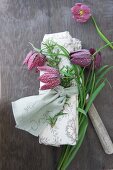 Linen napkin tied with rosemary sprig, name on ribbon and snake's head fritillary