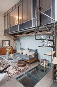 Living space in industrial loft apartment with spiral staircase leading to mezzanine