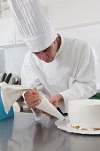 Hispanic chef decorating cake