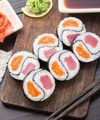 Yin yang futomaki with tuna and salmon on a wooden board