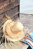 Hand-made straw hat leaning against wooden wall