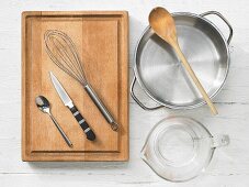 Kitchen utensils: pot, measuring cup, spoon, knife, whisk