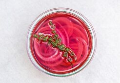 Eingelegte rote Zwiebeln mit Thymian im Glas (Aufsicht)