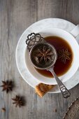 Tee in Tasse mit Teesieb und Gewürzen (Aufsicht)