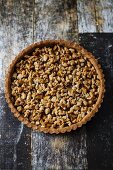 Gluten free tart with chestnut eggless crust, filled with marmelade, candied apples and walnuts