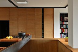 Open-plan, wooden designer kitchen with metal counter and gas cooker