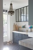 Vintage-style kitchen with grey cabinets and chandelier