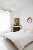 White bedroom with corner fireplace and floating bed