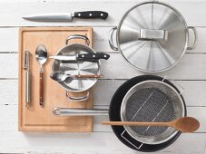 Various kitchen utensils: pots, steamer, knives, spoon, peeler