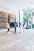 Futuristic dining table on stone floor next to panoramic window