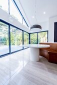 Round table and bench in front of gable-end wall with panoramic windows