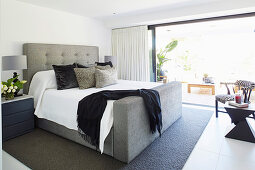 Modern upholstered bed in the bedroom in shades of gray