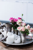 Tin cup with roses and candles on tray