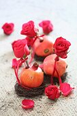 Romantic arrangement of roses and pomegranates on table