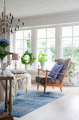 Scandinavian-style living room with row of large windows overlooking garden