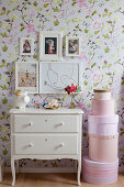 Pictures above vintage-style chest of drawers and stacked pink hat boxes