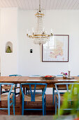 Kronleuchter überm Esstisch mit blauen Designerstühlen