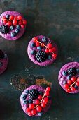 Vegan raw berry tarts on a black background
