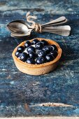 Blueberry tart on blue wooden background