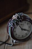 Glass-bead jewellery on vintage alarm clock