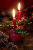Christmas arrangement of candles in apples and larch branches